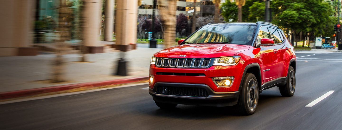 Jeep Compass being driven down a city street.