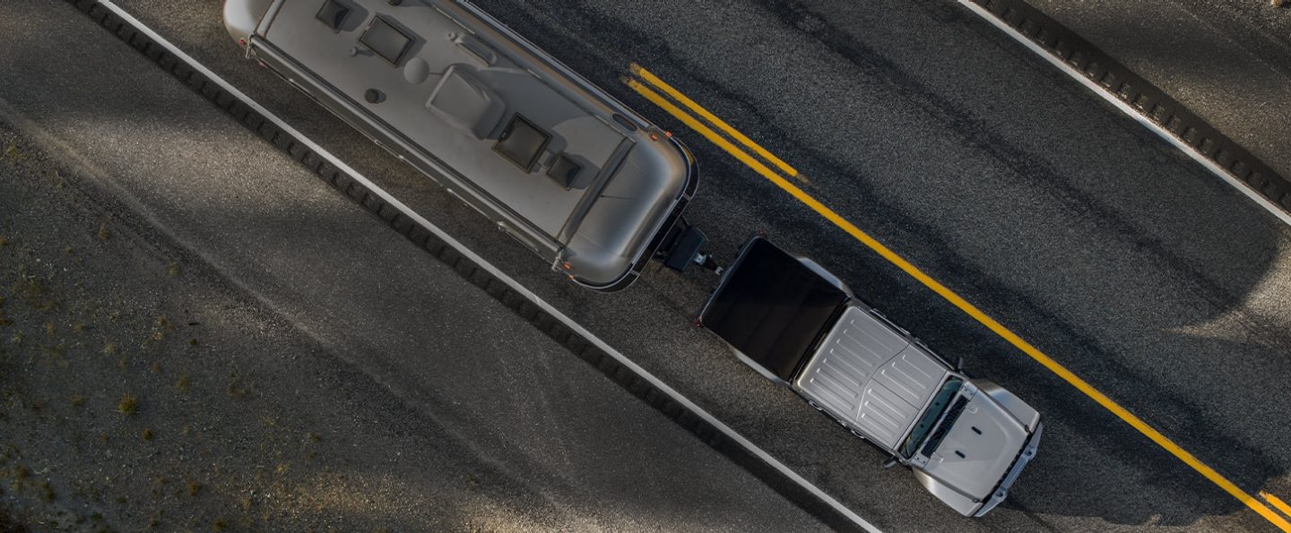 A bird's-eye view of the 2022 Jeep Gladiator Overland towing a camper trailer.