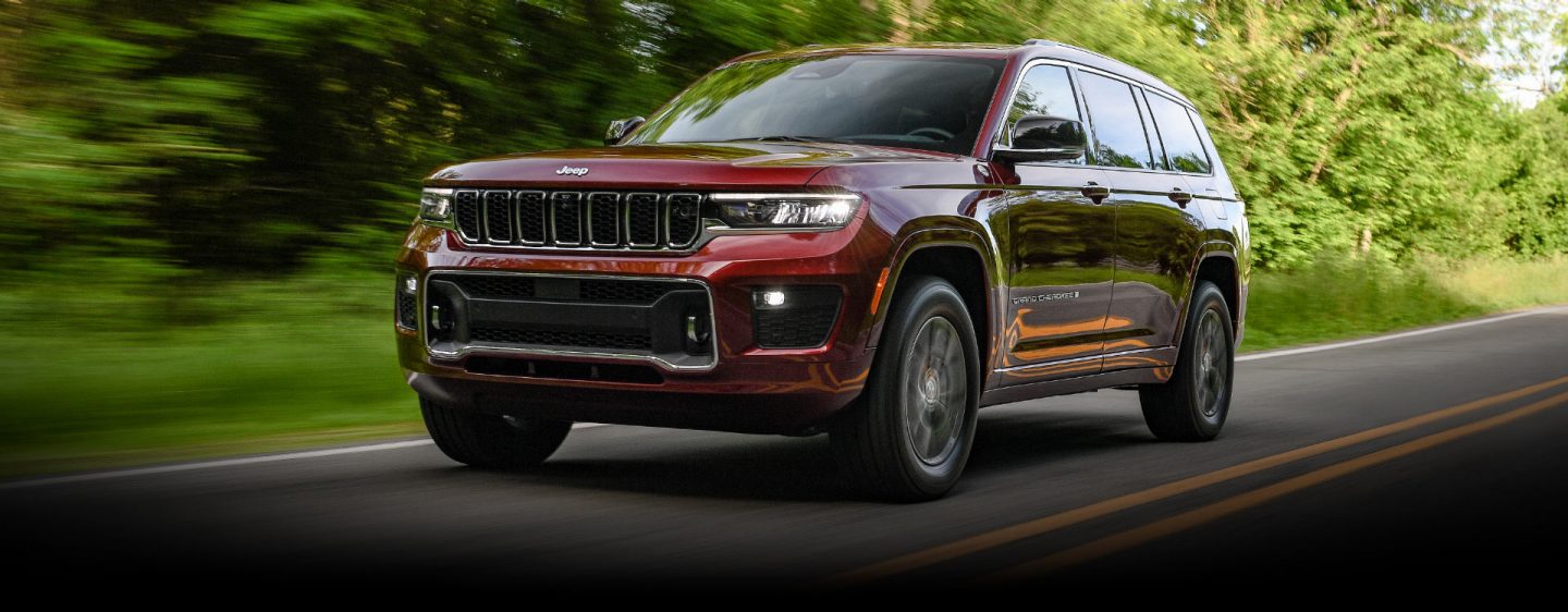 The Jeep Grand Cherokee Overland being driven on a road with the trees in the background blurred to indicate the vehicle's speed.